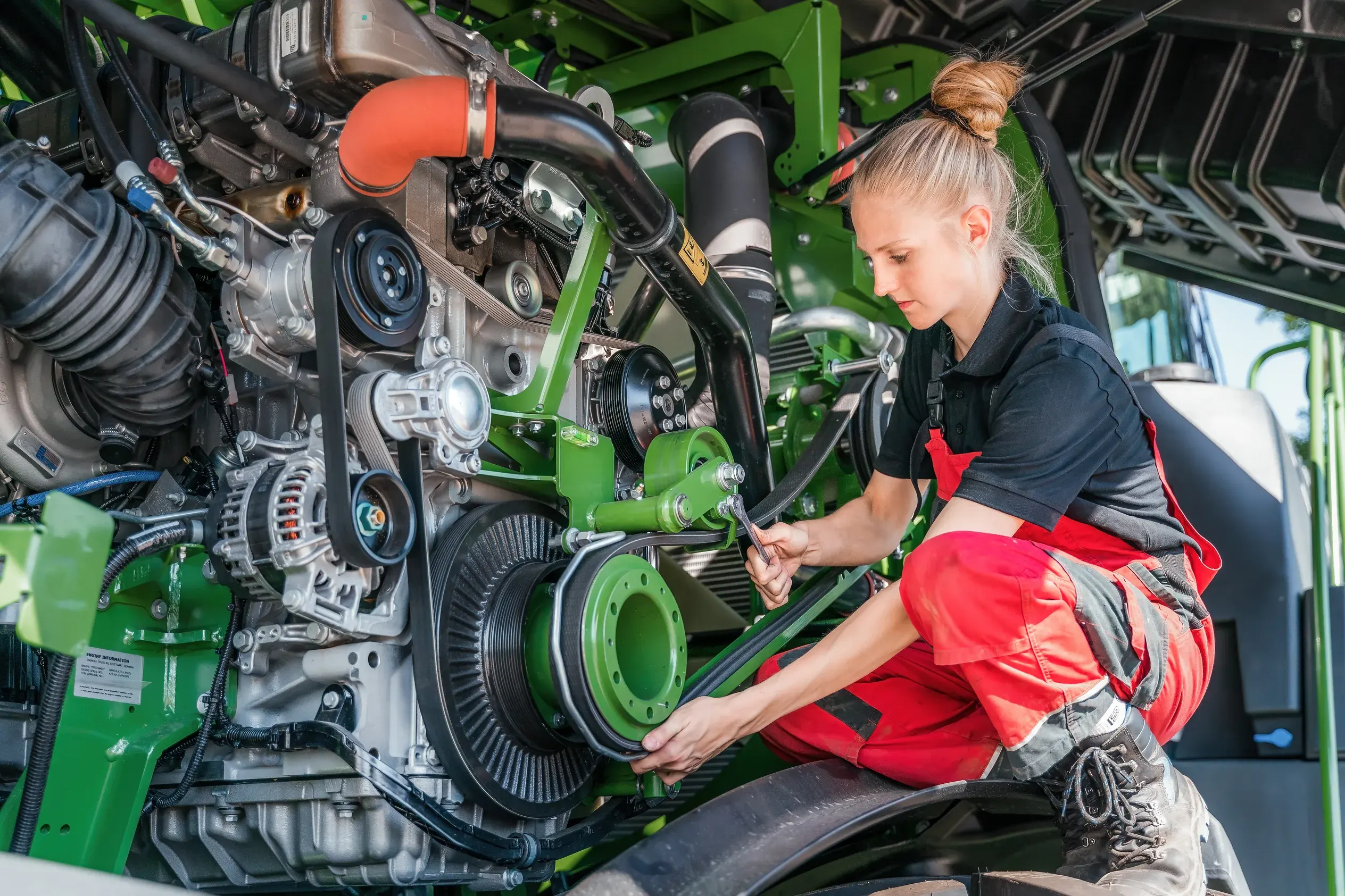 Firmenportrait: Mechanikerin bei der Arbeit am Motor einer Landmaschine – Patzsch Werbefotografie
