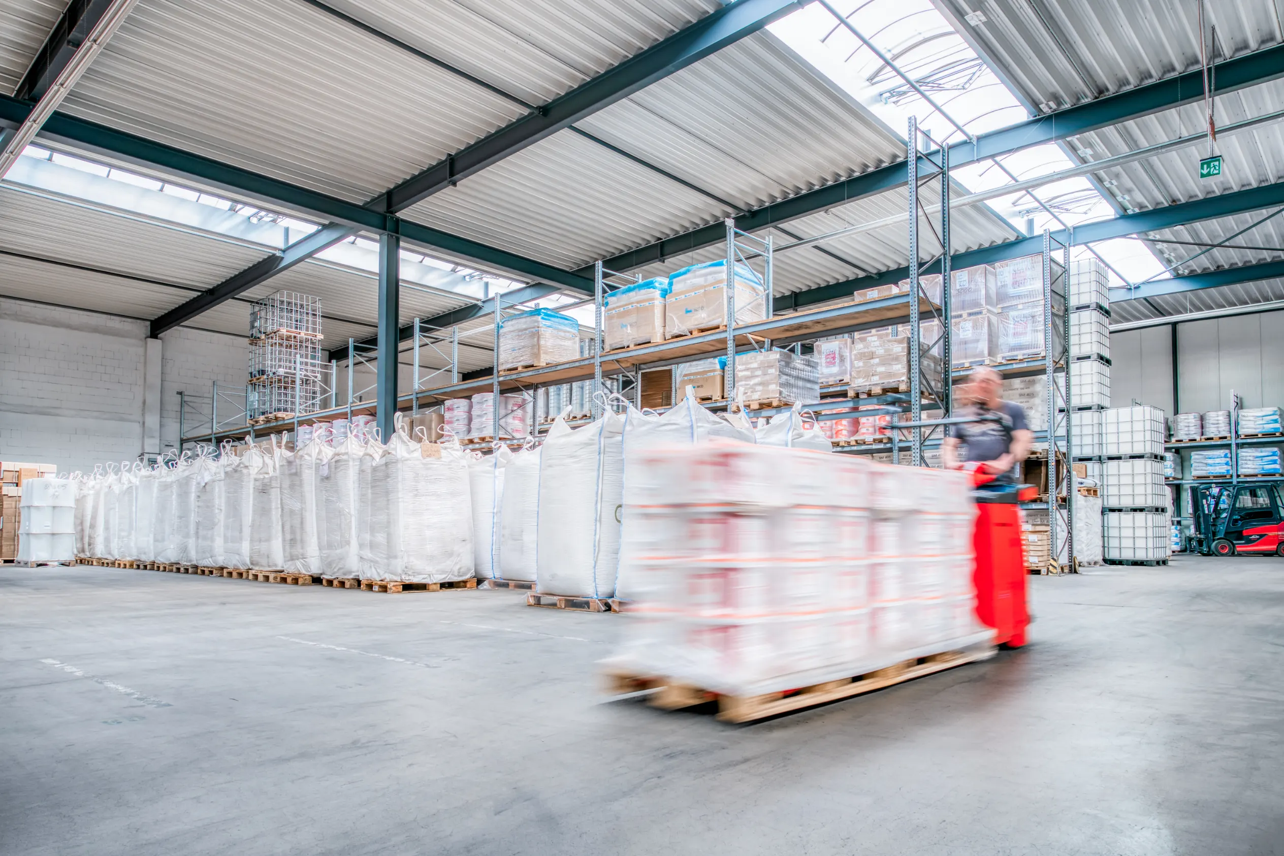 Industriefotografie: Lagerhalle mit Hubwagen in Bewegung, Regale und Big Bags – Patzsch Werbefotografie
