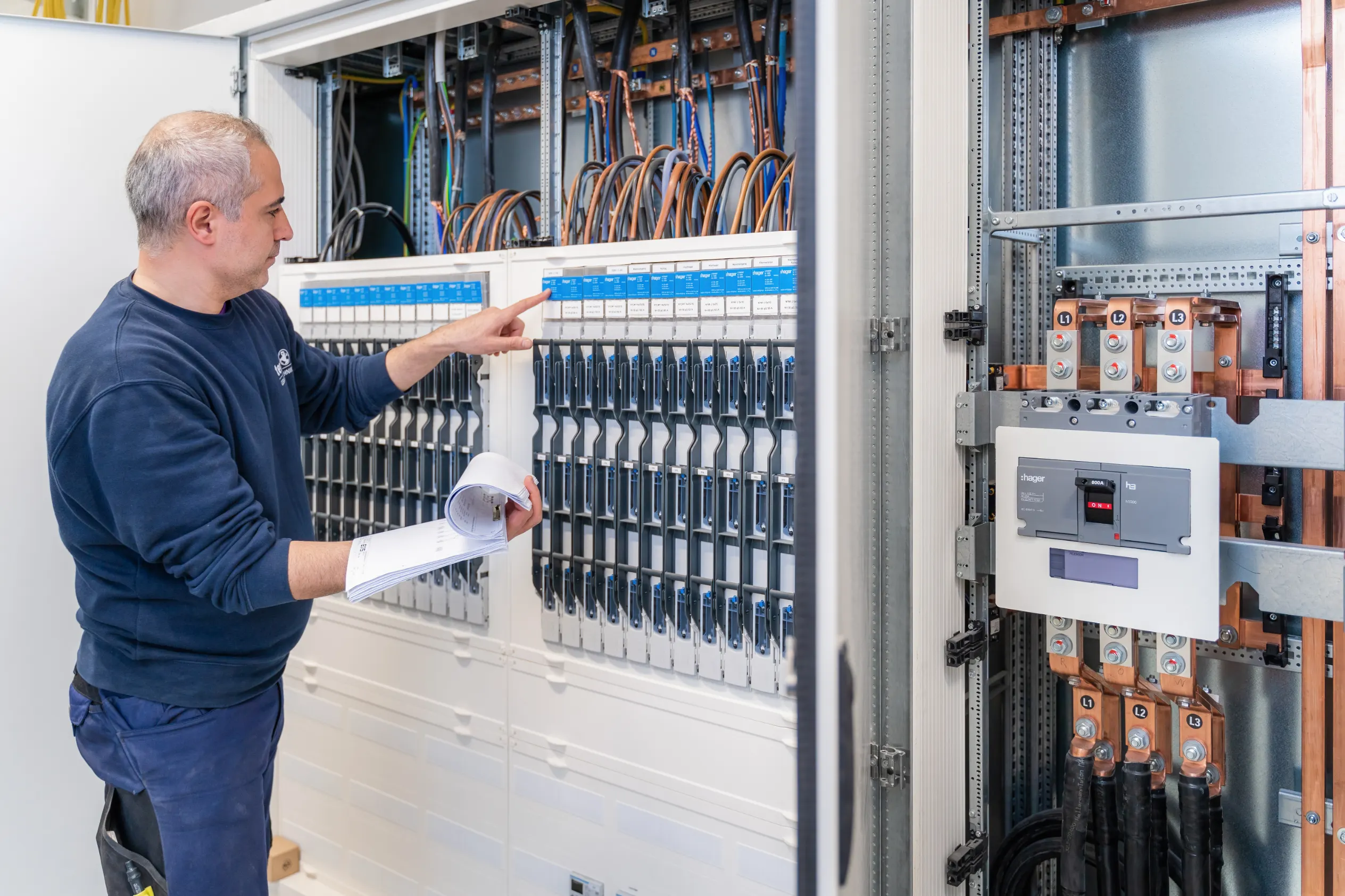 Elektrofachkraft prüft eine Schaltanlage – Reportageaufnahme bei laufender Arbeit – Patzsch Werbefotografie