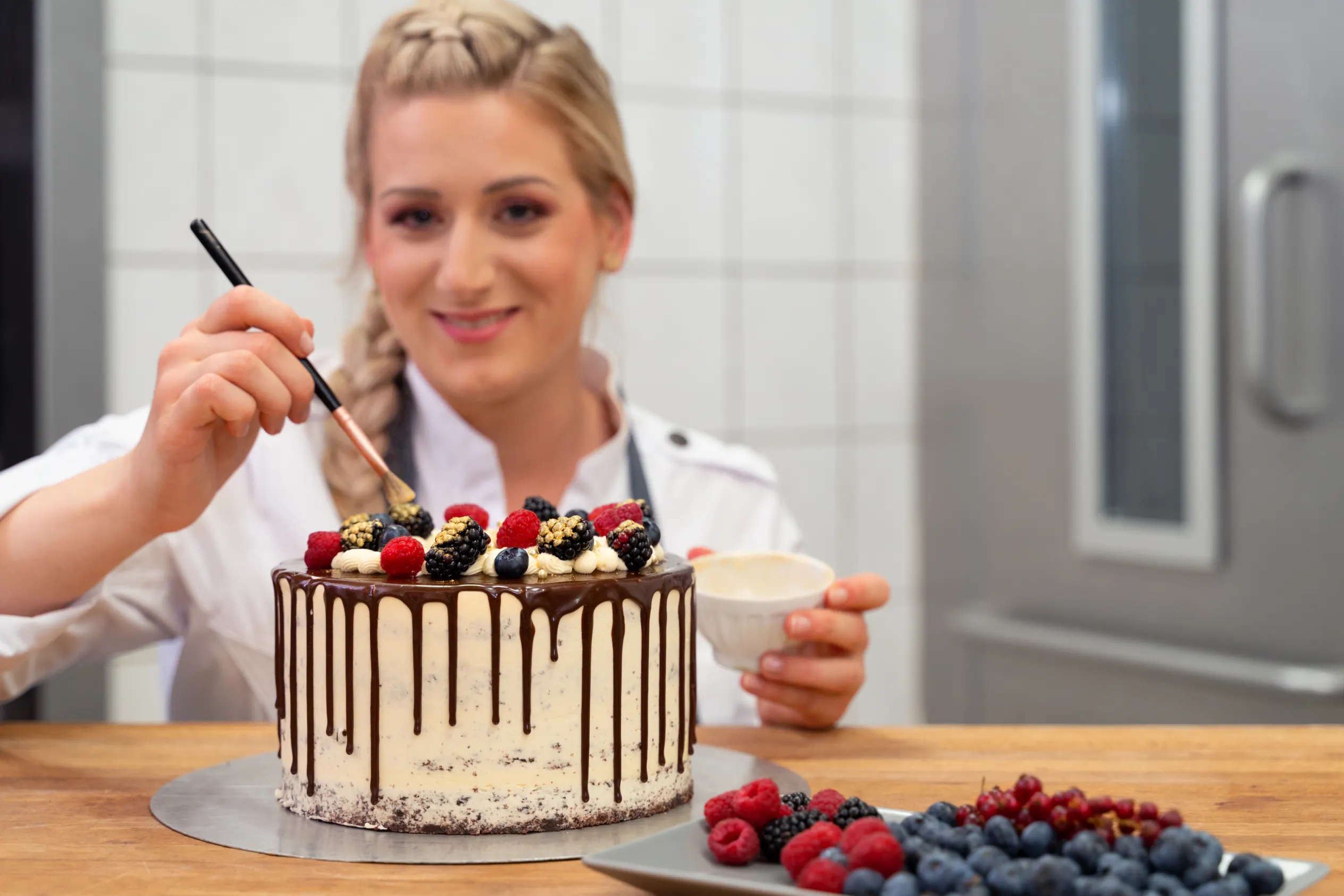 Werbefotografie: Konditorin veredelt eine Torte mit Goldstaub – Patzsch Werbefotografie
